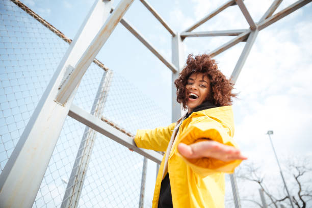 istock Smiling african curly young lady wearing yellow coat 1355693701
