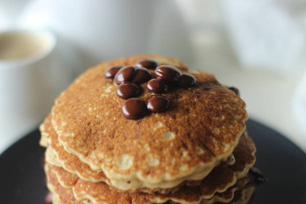 istock Stack of Oats Choco chips pancakes along with coffee for breakfast. Healthy pancakes made of oats flour loaded with chocolate chips 1355696087