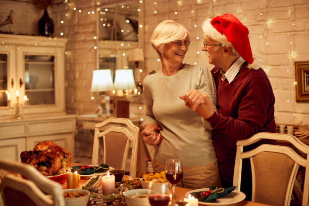 istock Happy senior couple talking while preparing dining table for Christmas dinner. 1355696135