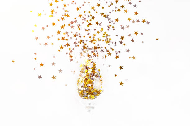 istock Christmas background.Simple minimalistic Christmas home decor.Flat lay,top view.Festive composition of a glass of champagne and glitter on a light background.Copy space. 1355700140