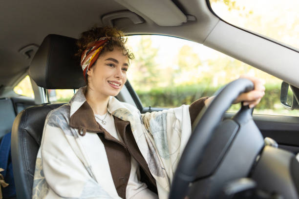istock Young female driver sitting in car 1355700373