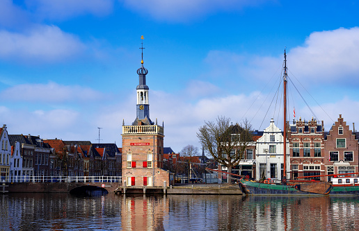 The Accijnstoren, excise tax tower, in Alkmaar, Netherlands, along a canal and 16th century houses