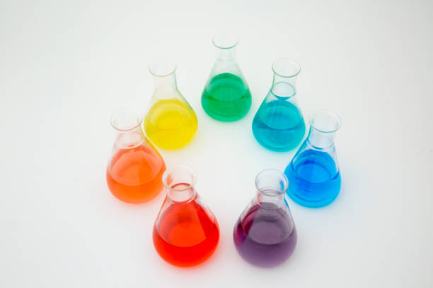 istock Scientific laboratory glass erlenmeyer flask filled with colorful liquid forming rainbow on white background. 1355703989