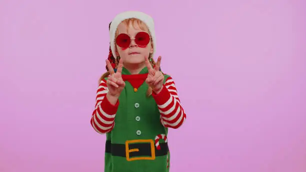 Photo of Girl Christmas Santa Claus Elf listening music via earphones dancing disco fooling around having fun