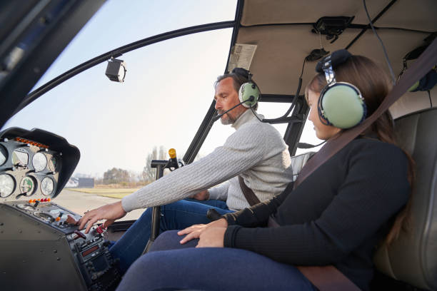 istock Focused man in safety gear flying a helicopter with kid 1355710013