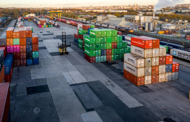 Aerial view of a busy shipping container terminal with stacked boxes Leeds, UK - November 22, 2021.  Aerial view of a busy shipping container rail terminal in Leeds with shipping boxes waiting to be loaded onto road and rail transport stacker stock pictures, royalty-free photos & images