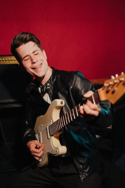 istock Young male hipster recording new sounds at studio while playing electro guitar and singing 1355710077