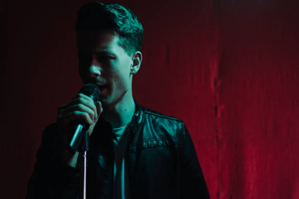 istock Man in leather jacket performing on a dark stage in club 1355710448