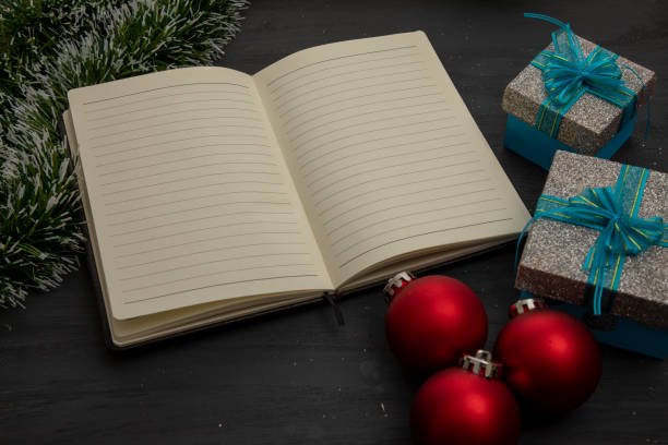 istock Open notebook on a black wooden background and Christmas decoration 1355712908