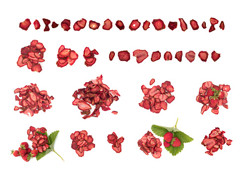 Group of home cooked dehydrated dry strawberries isolated on white background top view. Dried homemade sliced organic strawberry berries close up