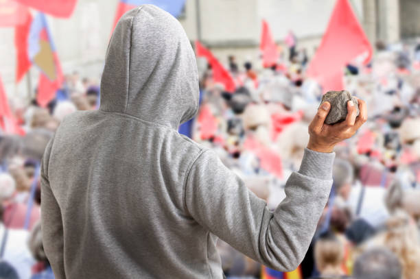 vandals of a protest march - throwing people stone tossing imagens e fotografias de stock