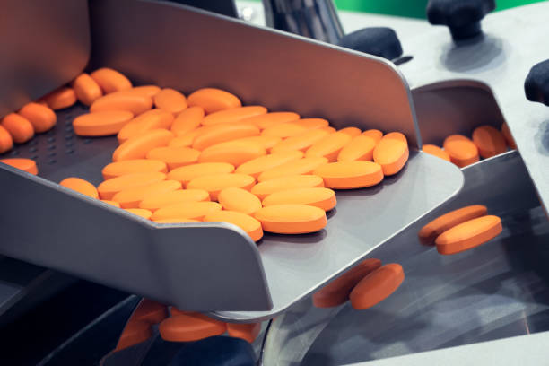 pharmaceutical production line, production of tablets or vitamins manufacturing, tablet conveyor - farmaceutische fabriek stockfoto's en -beelden