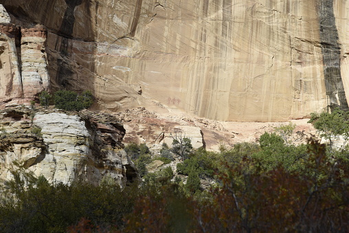 Red pigmented pictographs of the Freemont style rock art show three life-size figures on the wall of Calf Creek Canyon in Grand Staircase-Escalante National Monument.