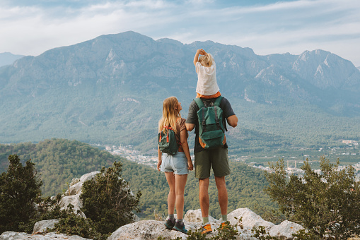 Family hiking parents with child outdoor travel in mountains active vacations lifestyle mother and father backpacking together with baby in Turkey