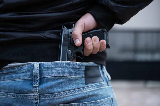 Man holding hidden handgun in his waist.