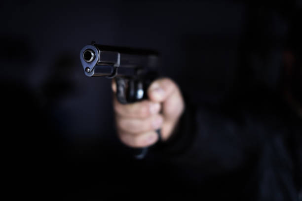 violence des armes à feu au pistolet noir - gun men holding handgun photos et images de collection