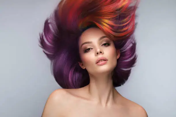 Photo of Beautiful woman with multi-colored hair and creative make up and hairstyle. Beauty face.