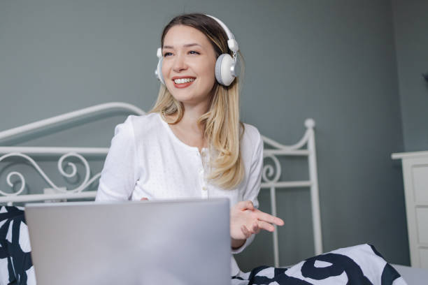 istock Young woman is using laptop in bed 1355732820