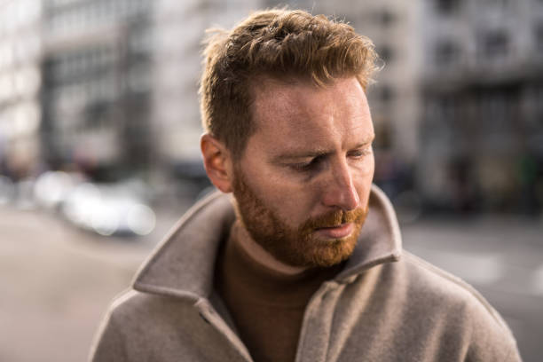 istock Sad man standing on city street. 1355732869