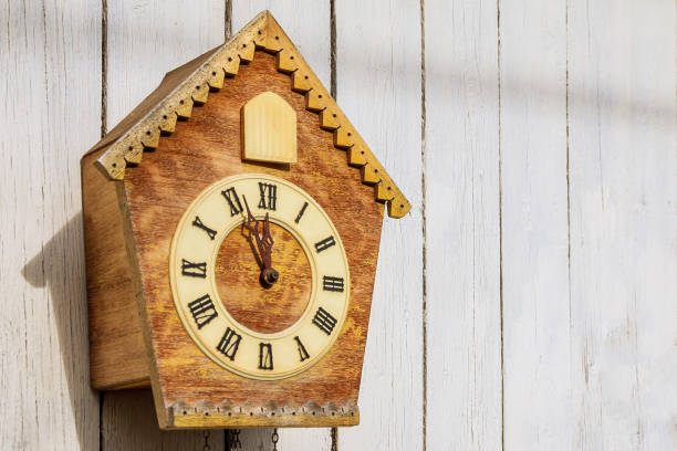 Old clock on a wooden light wall. Copy-space.