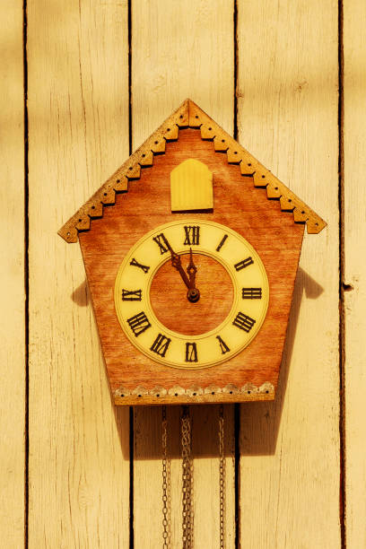 istock Old clock on a wooden light wall. Vintage clock. Cuckoo clock 1355733348