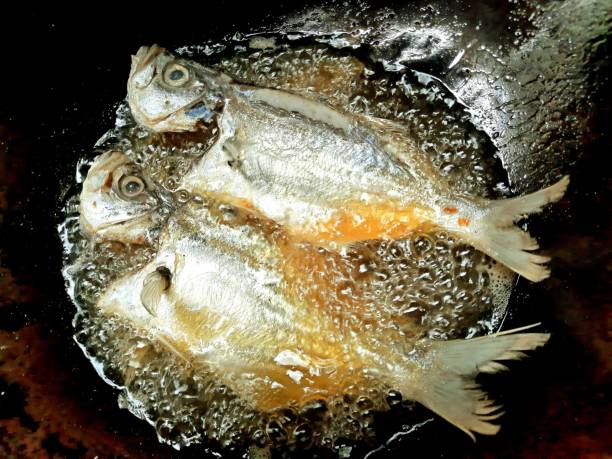 istock Frying Milkfish in cooking pan - food preparation. 1355734036