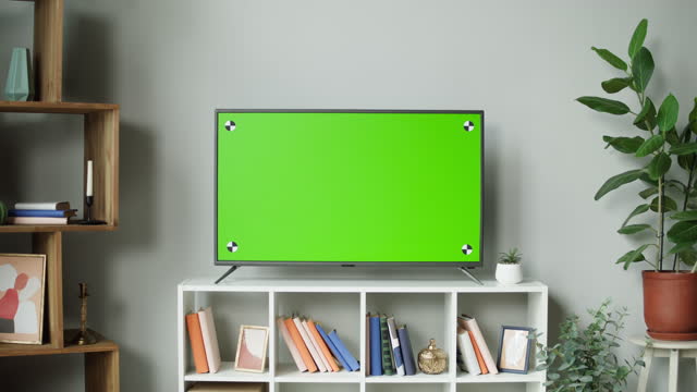 Television with green screen close-up. Chroma key on tv set in modern living room. Horizontal mock-up, domestic cinema concept