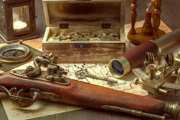 a compass, a sextant, a spyglass, an antique pistol, and a chest of gold on a table in the captain's cabin of a pirate ship. Still-life