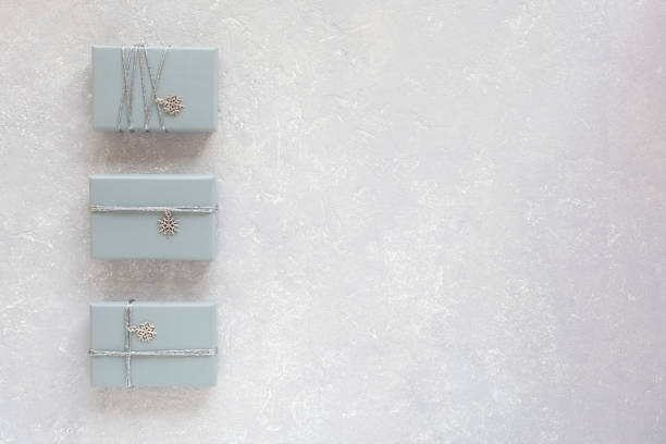 istock Grey gift boxes decorated with snowlakes on the grey cocnrete background 1355736674