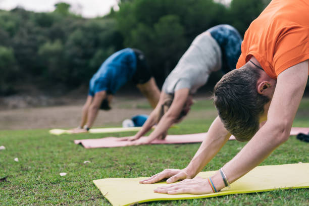 Three man doing yoga in a park stock photo