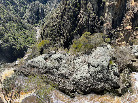 Horizontal landscape photo of the waterfall as seen from the top of the cascade as it plunges over steep rock cliffs at Dangar’s Falls in the Oxley Wild Rivers National Park in the New England high country near Armidale