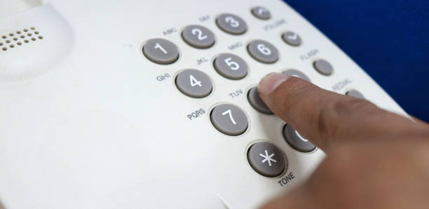 istock Finger is dialing a number on the phone to call someone 1355750681
