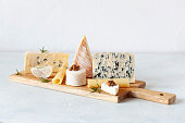 Different types of cheese on a cutting board