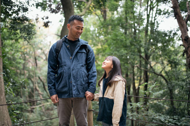 istock Father and daughter hiking in forest 1355755994