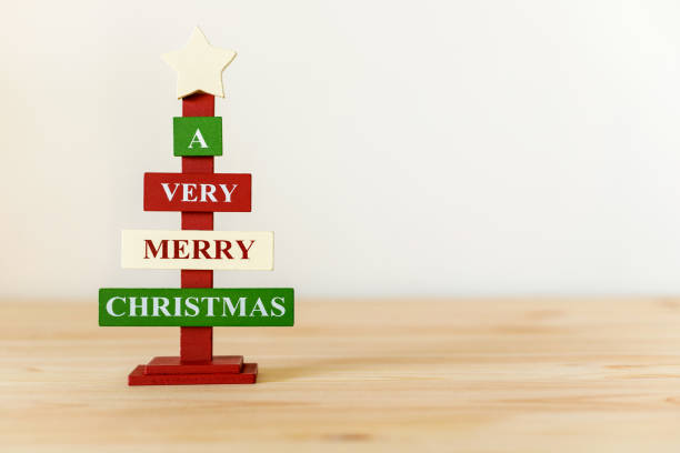 istock Christmas decorative wooden tree on table with copy space for text. A very Merry Christmas 1355759210
