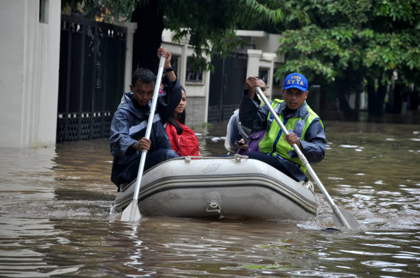 Rescue workers evacuate residents trapped by flood using rubber boats, Jakarta - Indonesia Jakarta, Indonesia - February 10, 2015 : Rescue workers evacuate residents trapped by flood using rubber boats, Jakarta - Indonesia jakarta slums stock pictures, royalty-free photos & images