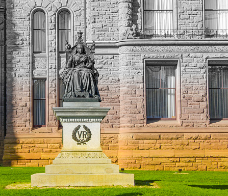A image photo graphed at downtown Toronto, near the Provincial Parliament of Ontario, Canada. Displaying a statue of Queen Victoria. in front of the Ontario Provincial Parliament building. This place is also directly neighbouring the St George Campus of University of Toronto.