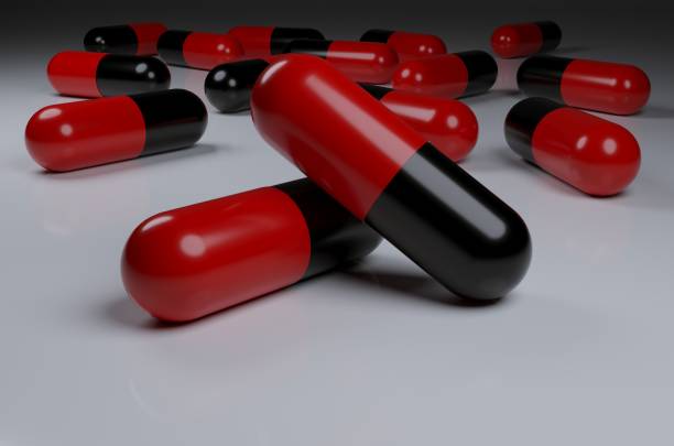 istock Selective focus of antibiotic red black capsule pills on white background 1355774070