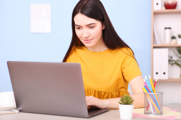 istock girl works at a laptop at home 1355776524