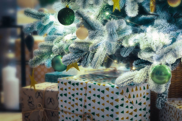 istock Christmas tree with different decoration and many gifts on blurred background with bright lights 1355777458