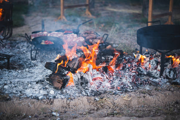 Two smoked tourist kettles over camp fire. Process of cooking on the nature
