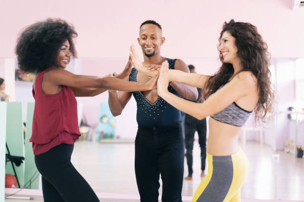 istock Salsa and latino dances class in a  professional studio. Brazilian dance instructor correcting the moves of multiracial young women. 1355780271