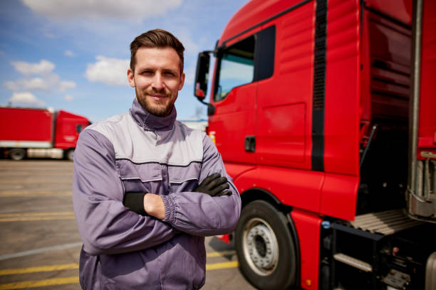 Truck driver in front of truck with arms crossed stock photo
