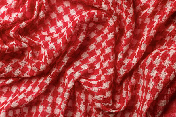 drapierter shemagh von rot-weißen farben hintergrund. arabischer wüstenschal hirbawi textur. gefaltete baumwolle keffiyeh makro. vollformat-kefia-muster. traditionelles nahost-kopftuch kufiya. - naher und mittlerer osten stock-fotos und bilder