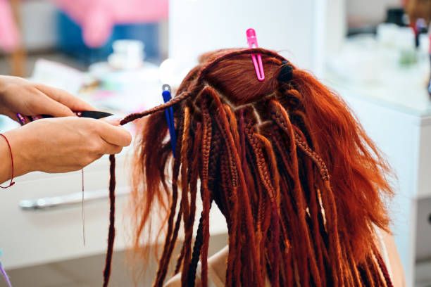 istock Braiding process african plaits with colored kanekalon. 1355785551