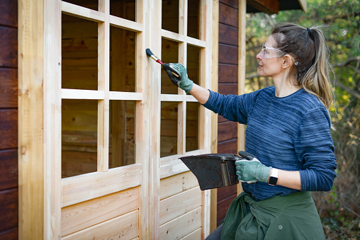 woman repairing a garden house