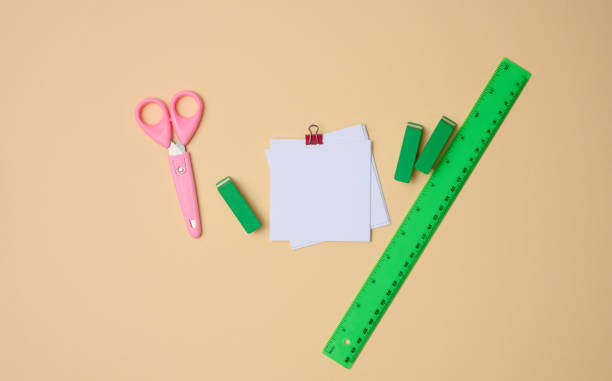 istock set of stationery objects ruler, blank white paper sheets ina beige background. View from abovegreen 1355785892
