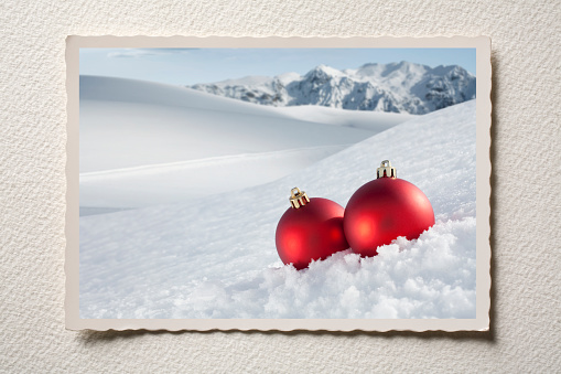 Old Christmas postcard with Christmas balls in snowy mountains.