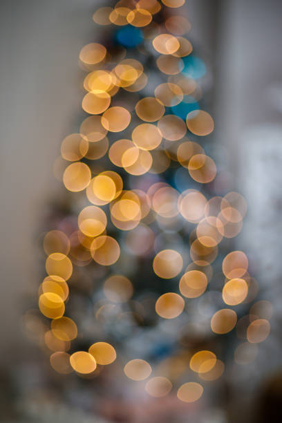 istock Christmas tree with defocused lights, festive vertical blurred background 1355788527