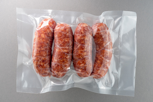 A tray containing a selection of fresh raw meats - white background